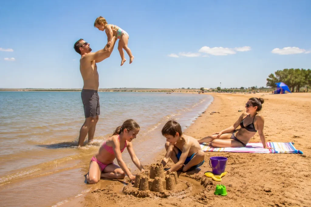 Family playing on the warm sandy beach at Jackson Lake State Park in Fort Morgan Colorado